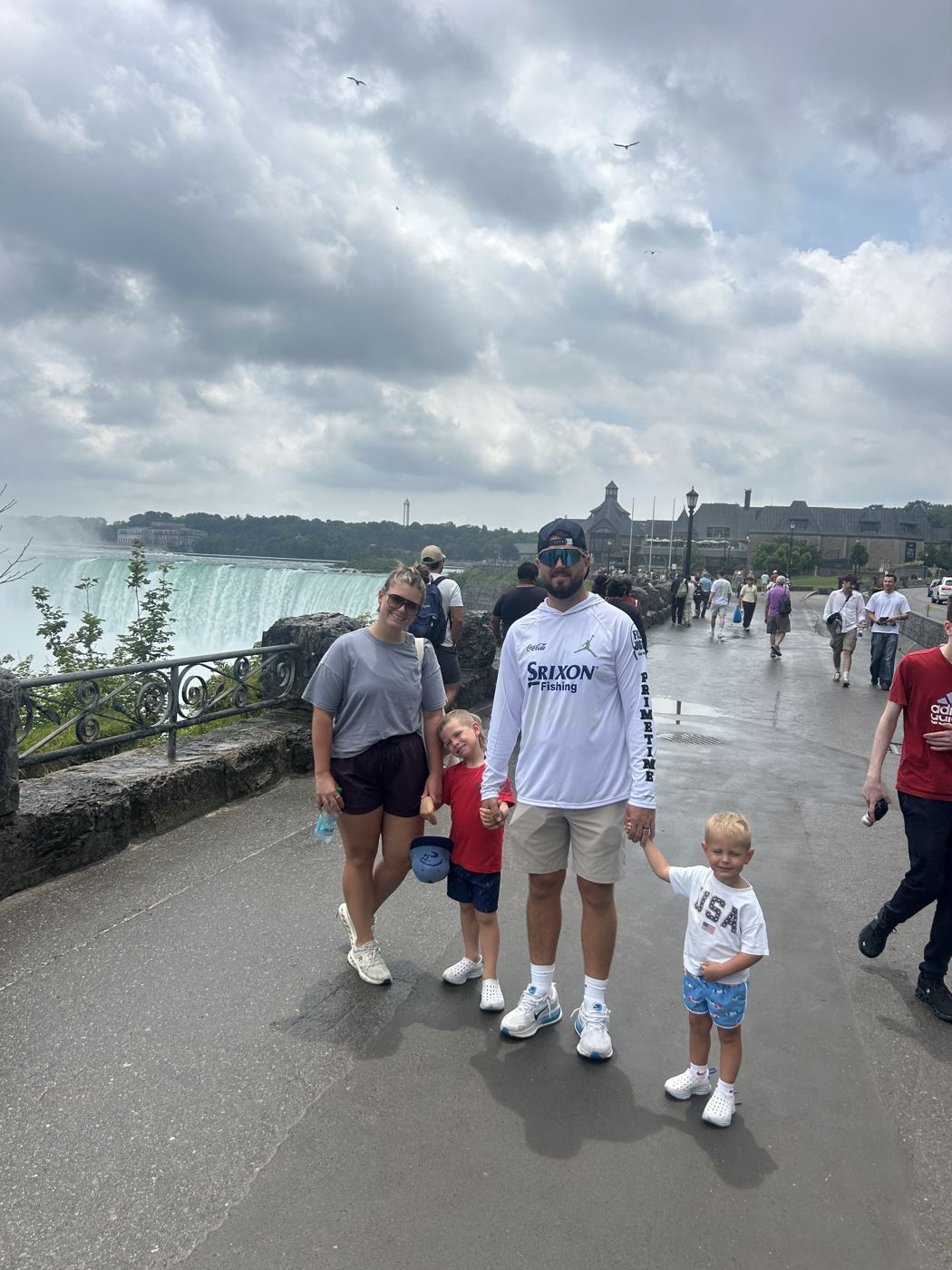 Une famille marche sur la promenade au-dessus de la rivière Niagara, les chutes en arrière-plan